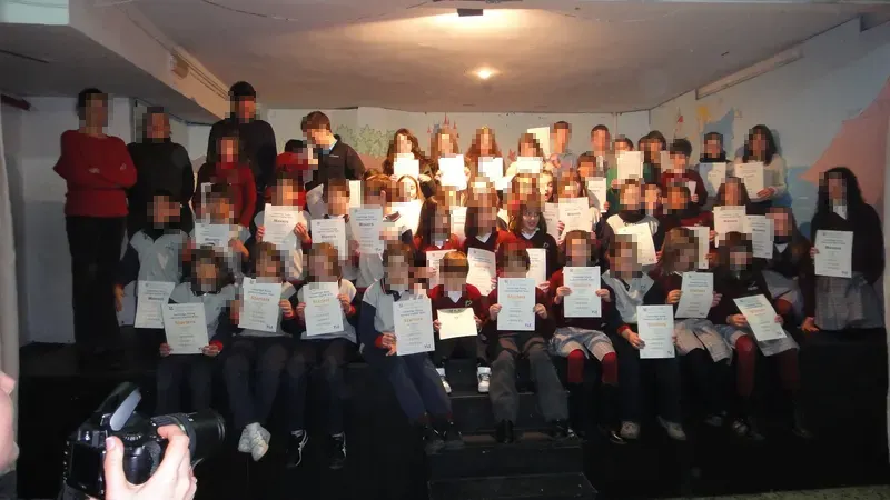 Grupo de alumnos posando en el escenario con sus diplomas