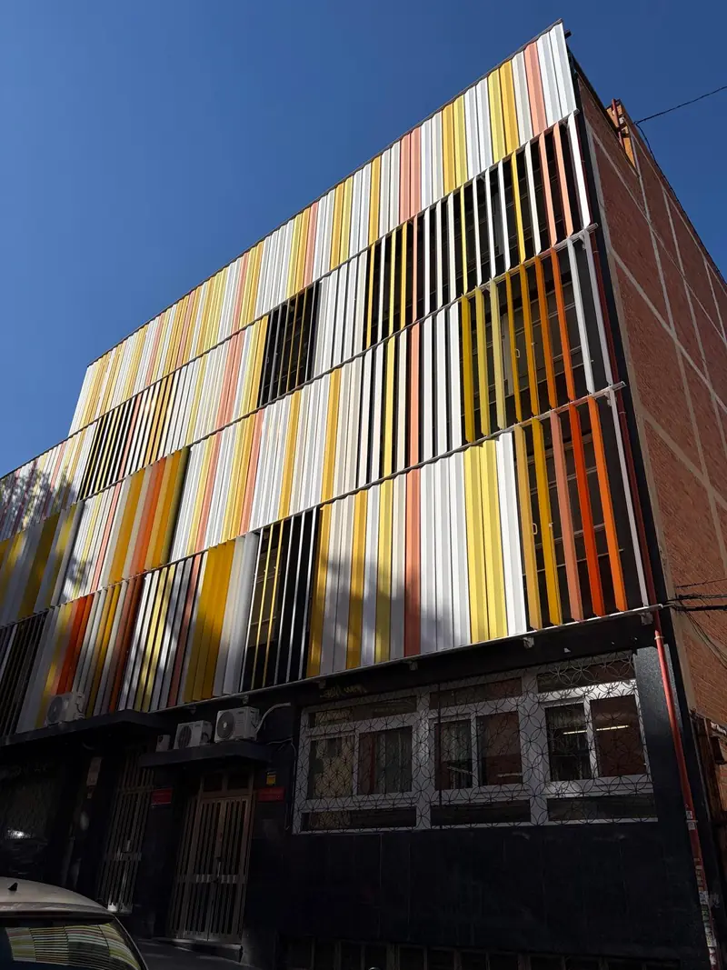 Fachada del colegio en la calle Tordo, con las lamas de colores y el rótulo del centro