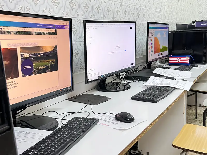 Aula de informática, con los ordenadores encendidos y las fichas del proyecto de clase